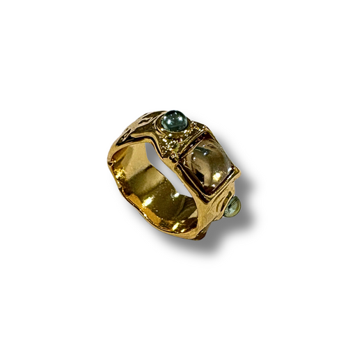 Gold ring with green gemstones on a white background