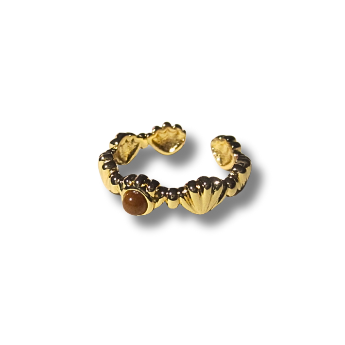 Gold ring with a central brown gemstone on a white background