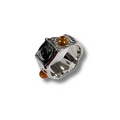 Silver ring with black and orange gemstones on a white background