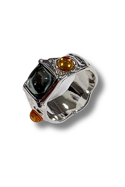 Silver ring with black and orange gemstones on a white background