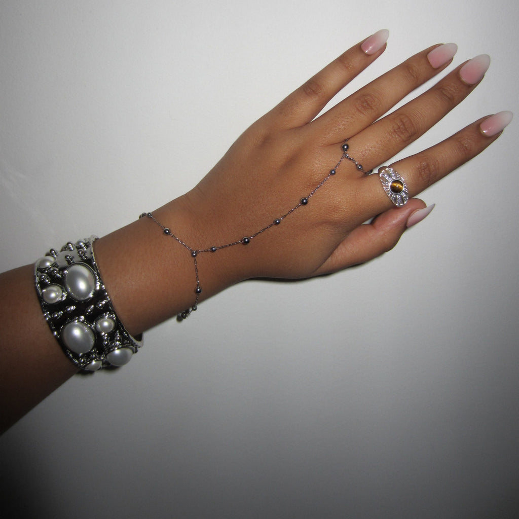 hand wearing a silver white bead bangle