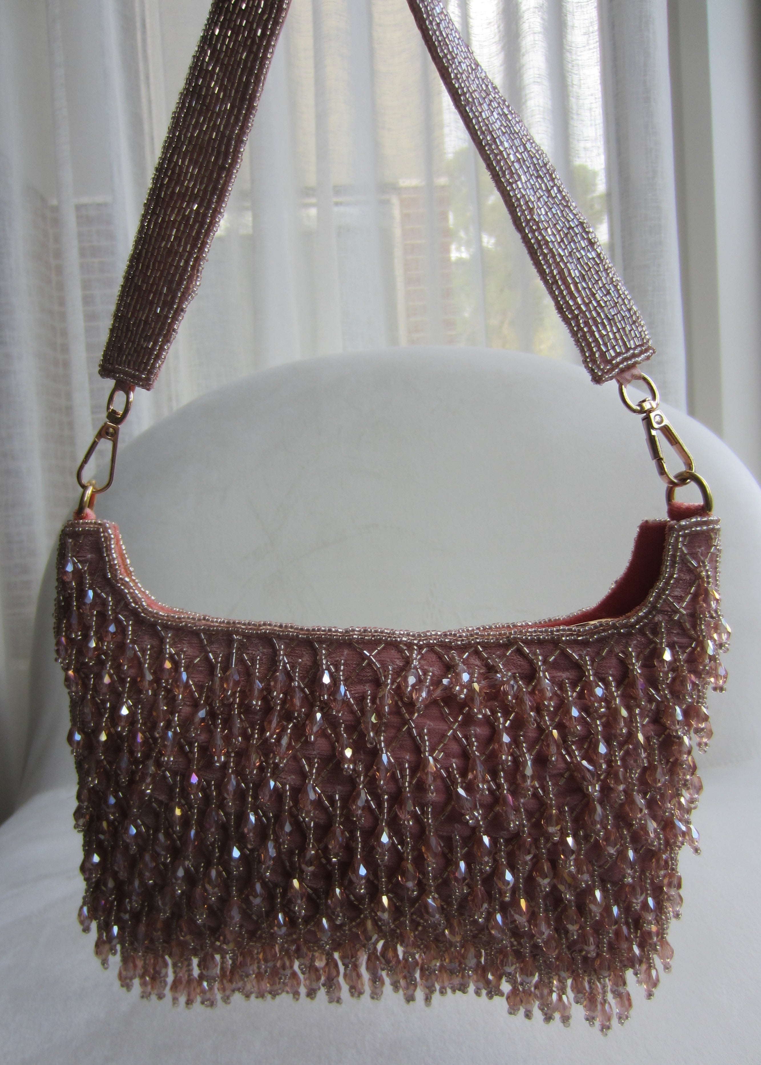 Beaded handbag with a strap on a white surface